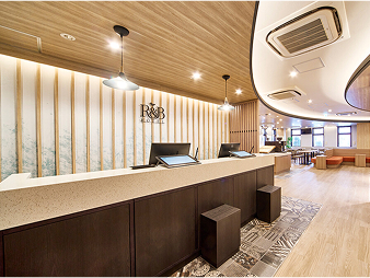 ワシントンR&Bホテルのフロントカウンター。木目調の天井と明るい照明で、落ち着いた雰囲気の受付スペース。