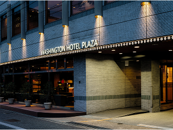ワシントンホテルプラザの夜のホテル外観。「WASHINGTON HOTEL PLAZA」とライトアップされた看板がある。
