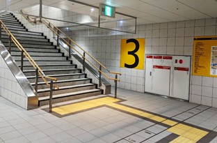 西改札口を出て、③出口の階段で1階へ上がってください。